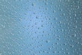 Beautiful water droplets of regular shape on frosted glass with blue light