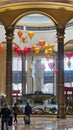 A beautiful water fountain with statues, Chinese lanterns, gold coins and lush green plants at The Venetian Resort and Hotel