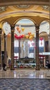 A beautiful water fountain with statues, Chinese lanterns, gold coins and lush green plants at The Venetian Resort and Hotel