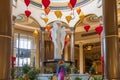 A beautiful water fountain with statues, Chinese lanterns, gold coins and lush green plants at The Venetian Resort and Hotel