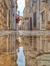 Water reflection of a narrow stone street in old town of Budva, Montenegro