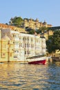 Beautiful water view of City Palace with touristic boat in Udaipur Royalty Free Stock Photo