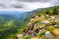 Beautiful waterfall above a deep green valley in the mountains