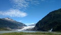 Beautiful Waterfall along side Mendenhall Glacier in Juneau Alaska. Large Glacier sliding into a lake with a waterfall beside it. Royalty Free Stock Photo