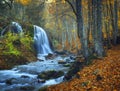 Beautiful waterfall in autumn forest in crimean mountains at sun Royalty Free Stock Photo