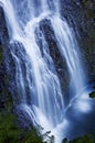 Beautiful waterfall cascading over rocks with a soft ethereal blue tone