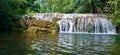 A beautiful waterfall of clear water between stones, in a forest surrounded by lots of greenery, trees and coconut trees Royalty Free Stock Photo