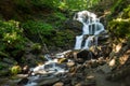 Beautiful waterfall comes out of a huge rock in the forest Royalty Free Stock Photo