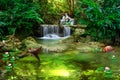 beautiful waterfall in forest with palm trees and boat