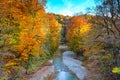 Beautiful waterfall in forest at sunset. Autumn landscape, fallen leaves Royalty Free Stock Photo