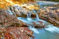 Beautiful waterfall in forest at sunset. Autumn landscape, fallen leaves Royalty Free Stock Photo