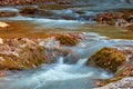 Beautiful waterfall in forest at sunset. Autumn landscape, fallen leaves Royalty Free Stock Photo