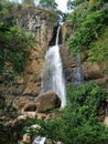 Beautiful waterfall in the forest, surrounded by green trees Royalty Free Stock Photo