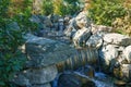 Beautiful waterfall in Japanese garden. Public landscape park of Krasnodar or Galician park, Russia Royalty Free Stock Photo