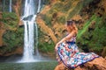 Beautiful waterfall in Morocco. Back of woman in beautiful dress looking fall Ouzoud. Exotic nature of North Africa, Royalty Free Stock Photo