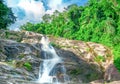 Beautiful waterfall at the mountain with blue sky and white cumulus clouds. Waterfall in tropical green tree forest. Waterfall Royalty Free Stock Photo