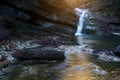 Beautiful waterfall at mountain river in colorful autumn forest with red and orange leaves at sunset. Nature landscape Royalty Free Stock Photo