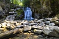 Beautiful waterfall in the mountain\'s forest with some rocks in front of it. Long exposure