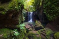 Beautiful waterfall in rainforest. Tropical landscape. Slow shutter speed, motion photography. Foreground with big stones. Nature Royalty Free Stock Photo