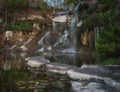 Beautiful waterfall in the rays of the evening sun. Waterfall in autumn