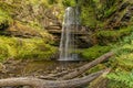 Beautiful waterfall surrounded by green foliage in a small valley (Henrhyd Falls