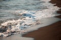 Beautiful waves of the sea foam on a sandy shore.