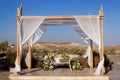 A beautiful Jewish wedding chuppah decorated with bright flowers and white curtains. Royalty Free Stock Photo