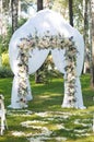 Beautiful wedding archway. Arch decorated with white cloth and flowers