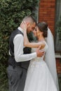 A beautiful wedding, a beautiful couple in love, laughing and kissing against the background of a green garden Royalty Free Stock Photo