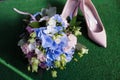 Beautiful wedding bouquet for the bride of blue pink and white flowers and stylish pink shoes Royalty Free Stock Photo