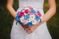 Beautiful wedding bouquet in brides and grooms hands on park background. White and blue daisies wedding bouquet Royalty Free Stock Photo