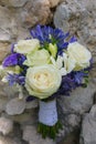 Beautiful wedding bouquet featuring ivory white roses, ivory freesias and fancy blue African lilies