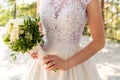 Beautiful wedding bouquet of flowers in hands of the bride. Bride holding elegant bouquet made of white roses. Royalty Free Stock Photo