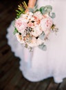 Beautiful wedding bouquet in the hands of the bride, modern stylish wedding concept, roses, peopy, eucaliptus, classic floristic s Royalty Free Stock Photo