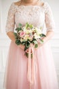 Beautiful wedding bouquet in hands of the bride. Rose, pink and Peach. Trendy and modern wedding flowers. Woman in wedding dress Royalty Free Stock Photo