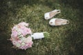 Beautiful wedding bouquet and a pair of white shoes laying on t Royalty Free Stock Photo