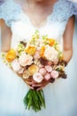 Beautiful wedding bouquet with pink and yellow roses in bride`s hands in wedding day. Wedding decor. Idea for bridal bouquet. Royalty Free Stock Photo