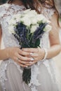 Beautiful wedding bouquet of roses and lavender in stylish bride hands on background of sunny street. Provence wedding. Bride Royalty Free Stock Photo