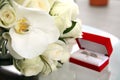 Beautiful wedding bouquet of roses and orchids and red velvet box with gold and platinum wedding rings