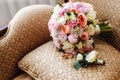 Beautiful wedding bouquet, two gold rings, boutonniere, lying on the armchair, wedding day. Important holiday accessories Royalty Free Stock Photo
