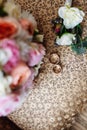 Beautiful wedding bouquet, two gold rings, boutonniere, lying on the armchair, wedding day. Important holiday accessories Royalty Free Stock Photo