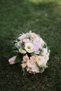 beautiful wedding bouquet of white flowers lies on the grass