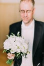 Beautiful wedding bouquet of white peonies in the hands of the groom.