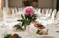 Beautiful wedding bouquet of white and pink peonies in white vase on dinner table in blur. Table setting at luxury wedding