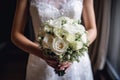 Beautiful wedding bouquet of white roses in the hands of the bride, bride holding a beautiful wedding bouquet close to her chest, Royalty Free Stock Photo