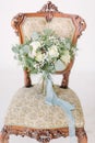 Beautiful wedding bouquet with white roses, pine and eucalyptus lying on the vintage chair. Royalty Free Stock Photo