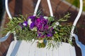 Beautiful wedding bouquet on a white wrought-iron chair.