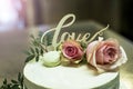 Beautiful wedding cake with cream With text Love on top pink flowers roses Royalty Free Stock Photo