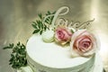 Beautiful wedding cake with cream With text Love on top pink flowers roses Royalty Free Stock Photo