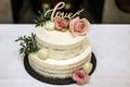 Beautiful wedding cake with cream With text Love on top pink flowers roses Royalty Free Stock Photo